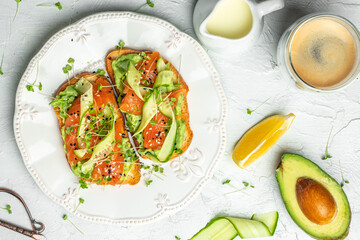 two toasts with salted salmon, guacamole avocado and fresh greens on plate. superfood concept. Healthy, clean eating. Vegan or gluten free diet. top view