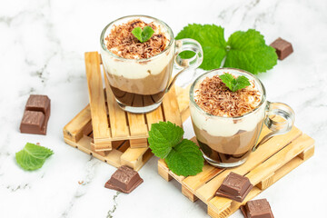 Dessert three chocolate in a glass jar on a wooden board. Food recipe background. Close up