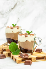 dessert three chocolates pudding decorated with mint on a light background. Layered delicious dessert. vertical image. top view. place for text