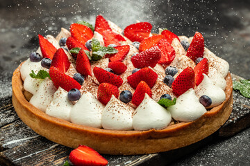 Homemade tart pie or cake with whipped cream and fresh strawberries, raspberries, blueberry. Food recipe background. Close up - obrazy, fototapety, plakaty