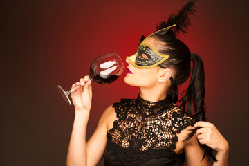 Venice carnival - woman with venice mask and a glass of wine for carnival party - 558838386