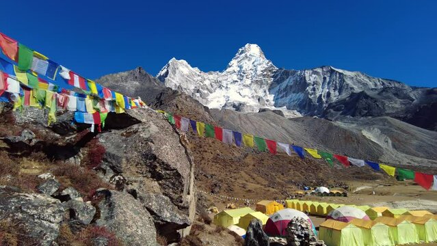 Ama Dablam, Nepal: Tibetan buddhism prayer flags at the Ama Dablam base camp above Pangboche on a sunny winter day in the Himalayas in Nepal. Shot with a pan to the right motion. 