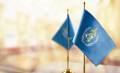 Small flags of the World Health Organization WHO on an abstract blurry background - 558842555