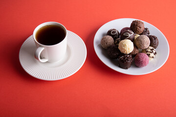 photo cup with coffee and different chocolates in a plate