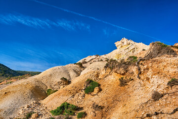 Natural rock formations of yellow cliffs on low sunlight, Milos