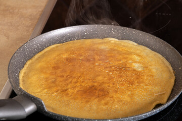 photo ruddy pancake lying on the pan