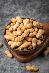 Peanuts in shell on dark background. Peanuts in a coconut bowl. close up