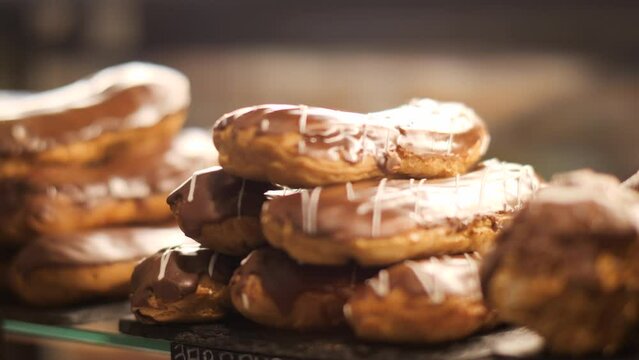 Fresh baked eclair on counter in confectionery. Various desserts in fridge