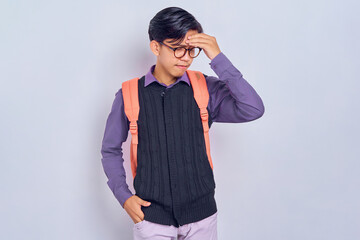 tired young Asian student man in casual clothes with backpack Keeping his eyes closed, put hand on...