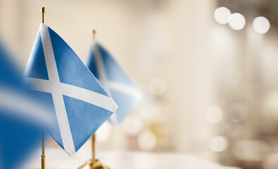 Small flags of the Scotland on an abstract blurry background