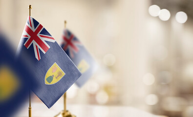 Small flags of the Turks and Caicos Islands on an abstract blurry background