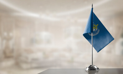 A small World Health Organization WHO flag on an abstract blurry background