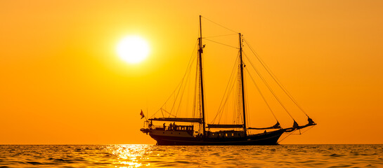 Zweimaster segelt während des Sonnenuntergangs auf der Ostsee