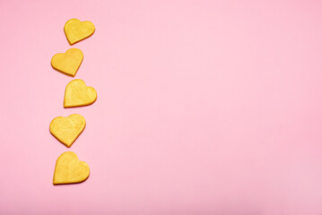 Multiple yellow hearts on a pink background.