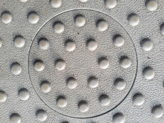 Circular pattern texture on rubber mat for non-slip purpose in park outdoor sports equipment.