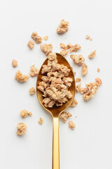 Granola on spoon on light background.