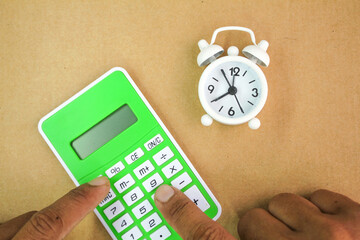 fingers pressed calculator numbers and the alarm clock was set aside. the concept of time to count....