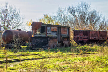 Fototapeta na wymiar abandoned railway station, rusty wagons, dilapidated building, landscape