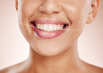 Floss, woman and smile with dental care, clean mouth and after brushing teeth against studio background. Oral health, Latino female and girl with string, fresh breath and morning routine for hygiene