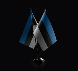 Small national flags of the Estonia on a black background