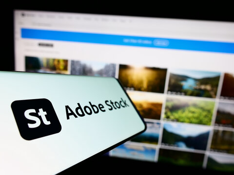 Stuttgart, Germany - 12-30-2022: Cellphone with logo of American microstock agency Adobe Stock on screen in front of business website. Focus on center-left of phone display.