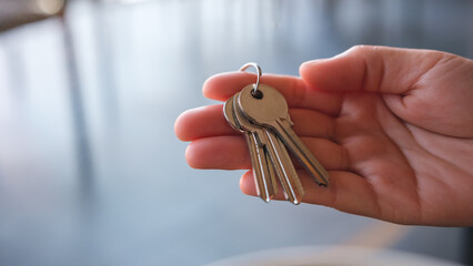 Closeup image of a hand holding the keys for real estate concept