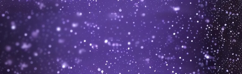 In a blurry background, there are abstract glittering blue, purple, and silver lights.