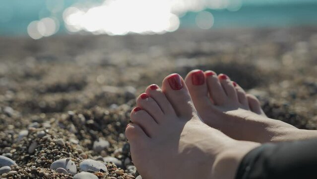 A small blond boy of 5 years old is playing on the beach near the sea with a toy truck. High quality 4k footage
