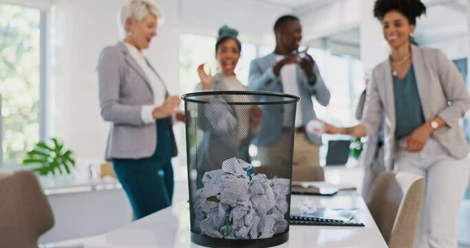 Office, trash and business people throw paper as a competition, game or challenge together. Happy, diversity and excited corporate team playing with with supplies in a bin for fun in the workplace.