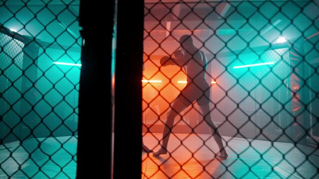 MMA fighters enter the cage ring. Mixed martial arts fight. Cinematic staged fight. Boxing in a ring or cage. Two fighters fight for the right to be the champion.
Boxer in the boxing gym. Bandages his