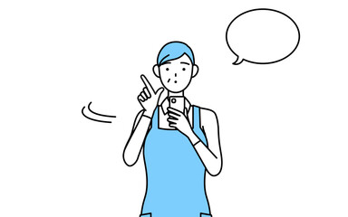 スマホを操作するエプロンを着たシニア女性