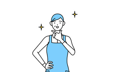 自信家のポーズを取るエプロンを着たシニア女性