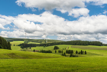Green hilly landscape in Black Forest, wind turbines on hills surrounded by fir forest, St. Peter,...