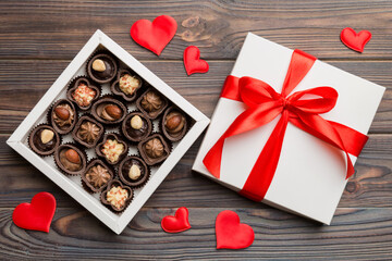 Delicious chocolate pralines in red box for Valentine's Day. Heart shaped box of chocolates top view with copy space