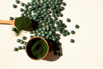 Spirulina tablets on a white background with contrast shadows. Flat style.