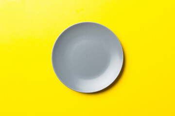 Top view of isolated of colored background empty round gray plate for food. Empty dish with space for your design