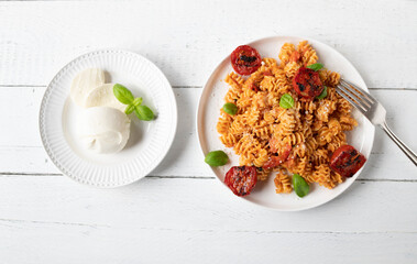 Pasta with mozzarella cheese sauce on a plate isolated on white background. Flat lay