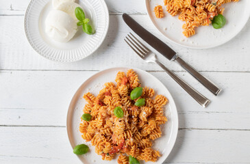 Pasta with tomato and mozzarella on a plate. Flat lay