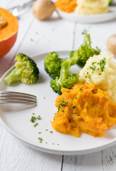 Plate with healthy, warm and gluten free side dishes. Such as broccoli, mashed potatoes and red kuri squash puree