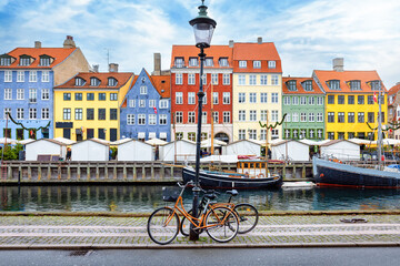 The popular Nyhavn area at Copenhagen, Denmark, with a street light and bicycles in front of the colorful houses - 558864399