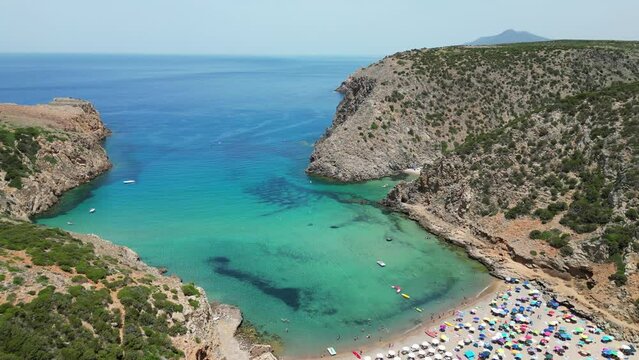 Tourists Swim and Relax at Cala Domestica Beach in Buggerru, Sardinia, Italy - 4k Aerial