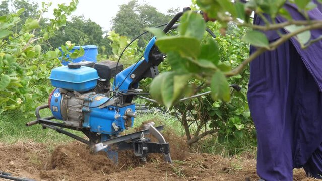 Pakistani Farmer Pushing Petrol Tiller Cultivator Over Ground Soil In Sindh, Pakistan. Slow Motion
