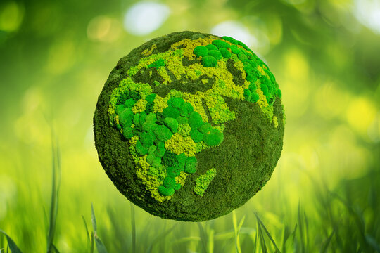 Green planet Earth from natural moss on a blured nature background. Symbol of sustainable development and renewable energy	