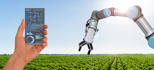 A farmer controls agricultural robot through a smartphone mobile application. Smart farming and...