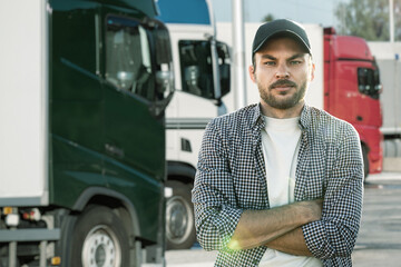 Truck driver standing in front of trucks	