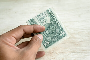 One dollar bill in human hand