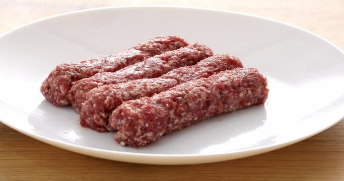 sausages from raw minced meat on a white plate. national Balkan food