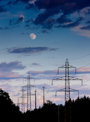 Strommasten im Gegenlicht mit Mond