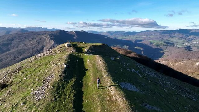 Hiker going up to the top of the mountain. Mount Trinidad de Erga, Navarra