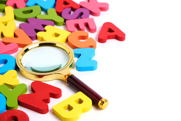 Magnifying glass and bright multicolored letters English alphabet white background.
